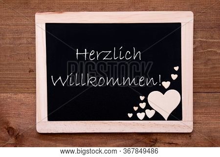 Balckboard With Wooden Heart Decoration, Text Willkommen Means Welcome
