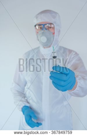Vaccination Of The Population. Viral Disease Concept.infectionist Doctor In A Protective Suit In Blu
