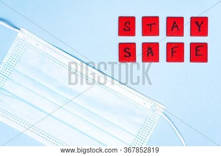Medical Protective Mask On Blue Background And Lettering Inscription Stay Safe. Disposable Face Mask