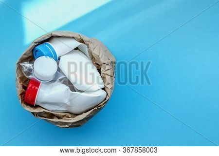 Paper Bag With Plastic Bottle On A Solid Blue Background For Recycle Waste. Waste Separation Concept