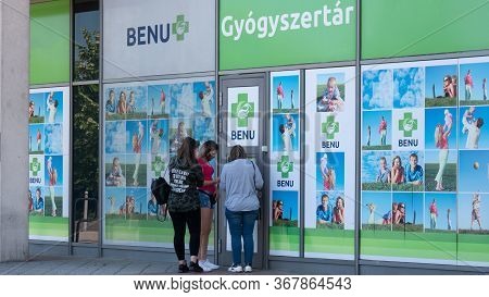 Gyor Hungary 05 22 2020: Young Girls Buy A Medical Protective Mask Against Coronavirus In A Benu Pha