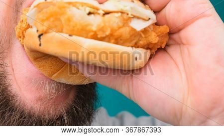 Close Up Of A Man Biting A Burger On A Chroma Key. The Concept Of Unhealthy And Unhealthy Diets, Hig
