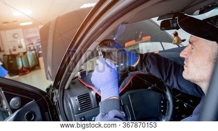 Automobile Special Workers Remove Old Windscreen Of A Car In Auto Service
