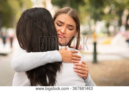 Bad Friend. Disgusted Girl Hugging Crying Girlfriend Pretending To Support Her Standing Outdoors. Fr