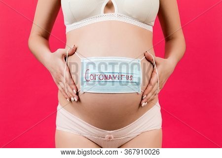 Banner Of Medical Mask On The Belly Of A Pregnant Girl. Hild Protection. Concept Of Coronavirus, Cov