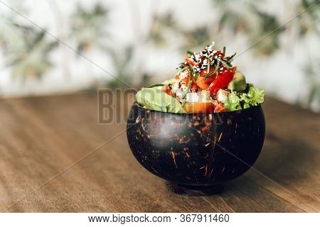 Poke Bowl With Tuna, Avocado, Vegetables And Sesame In Coconat Bowl On Pattern Background. Healthy, 