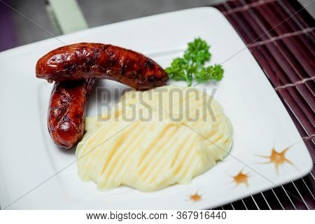Potatoe With Sousages On The White Plate. Barbecue. Restaurant.