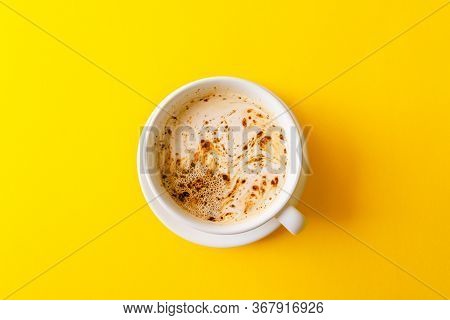 A Cup Of Black Coffee On Yellow Background.