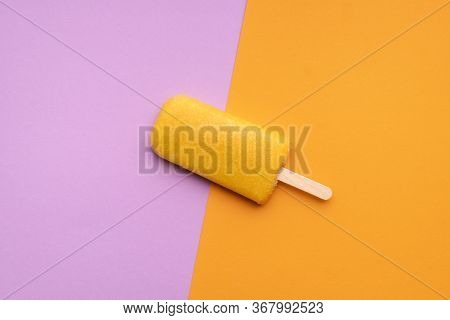 Orange Flavored Ice Cream Popsicle On A Seamless Colorful Background. Flat Lay Of One Fruity Popsicl