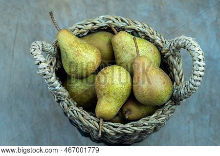 Pears In Basket On A Wooden Background. Fruit Harvest. Autumn Still Life. Pear Variety Bera Conferen