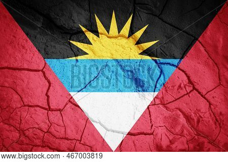 Flag Of Antigua And Barbuda. Antigua And Barbuda Symbol. Flag On The Background Of Dry Cracked Earth