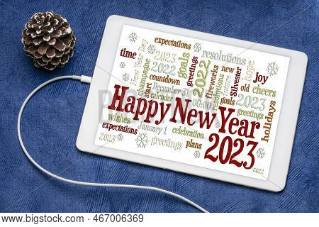 Happy New Year 2023 Greetings Card  - Word Cloud On A Digital Tablet With A Decorative Frosty Pine C