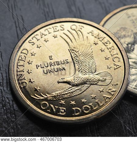 American Coins Close Up Lie On Dark Surface Of Office Table. Soaring Eagle Sacagawea Dollar Coin. Us