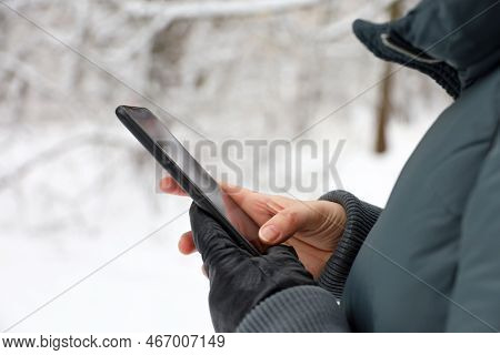 Female Hands With Smartphone Close Up On Blurred Background. Woman Using Mobile Phone Stands On A St