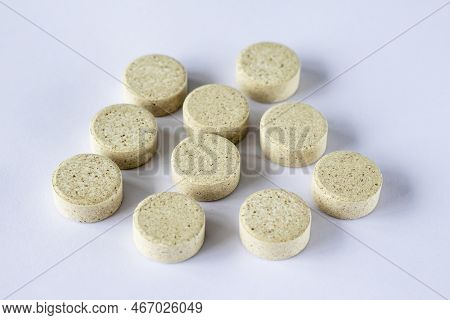 Round Puck Tablets Of Irregular Beige Color On A White Background. Supplements Dgl Liquorice Root