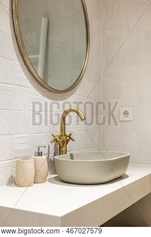 Oval Stylish Sink On White Smooth Marble Countertop In Modern Bathroom. Copper-colored Two-valve Fau