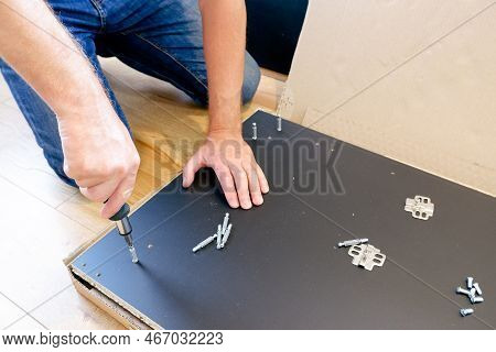 Assembling Furniture. Furniture Assembly Worker Assembles Shelf. Worker Assembling Furniture. Contra