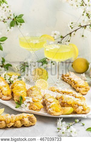 Traditional French Dessert Eclairs With Lemon Curd Topping. Limoncello Italian Lemon Liqueur, Restau