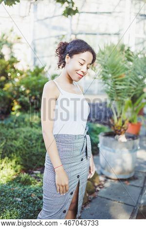 Young African American Multiracial Woman In Midi Pencil Skirt With Front Button Slit In Park Or Stre