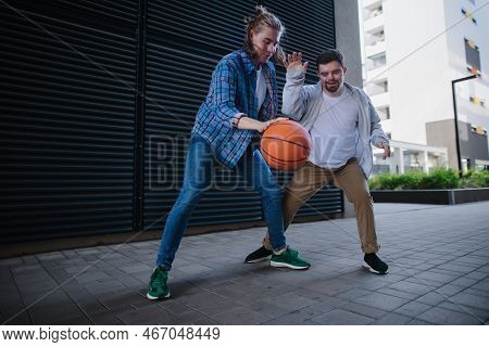 Man With Down Syndrome Playing Basketball Outdoor With His Friend. Concept Of Friendship And Integra