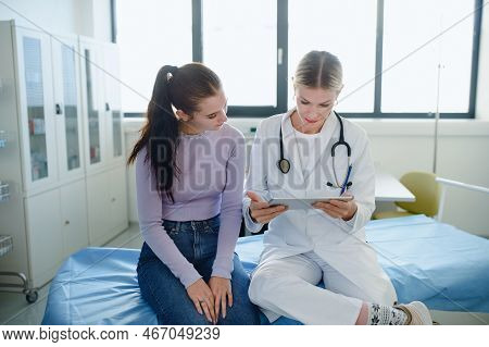 Young Woman Doctor Explaining Diagnosis To Teenage Girl In Her Ambulance.