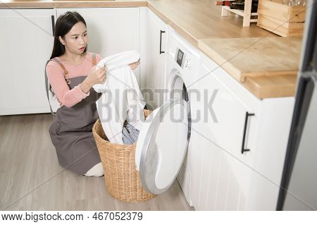 Exhausted  Asian Young Woman With Dirty Clothes , Doing Laundry In Home