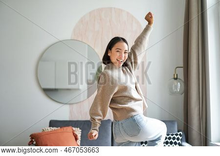 Cute Excited Asian Woman Dancing, Raising Hands Up In Triumph, Celebrating And Singing, Standing At 