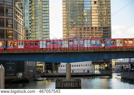 London - November 4, 2020: Docklands Light Railway Dlr Train Crosses Bridge Over Water At Canary Wha