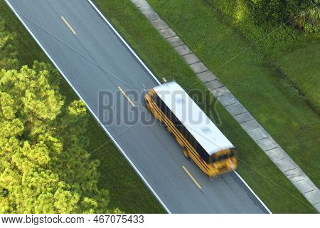 Aerial View Of American Yellow School Bus Driving On Suburban Street For Picking Up Children For The