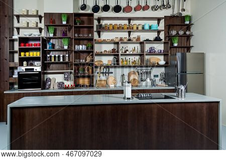 Working Area Of The Kitchen. Kitchen Cabinet With Jars, Cups, Spices, Plates, Kitchen Countertop Wit