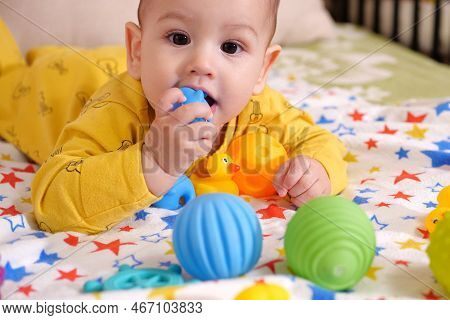 Cute Adorable Newborn Baby Playing With Colorful Rattle Toy. Baby With Teether. Six Months Old Lovel