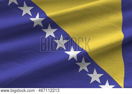Bosnia And Herzegovina Flag With Big Folds Waving Close Up Under The Studio Light Indoors. The Offic