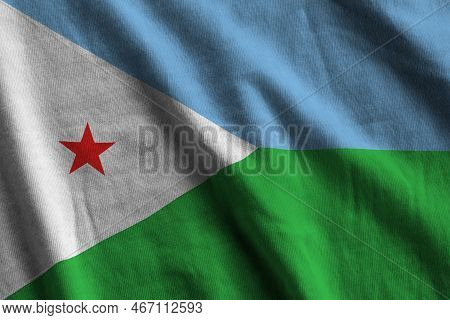 Djibouti Flag With Big Folds Waving Close Up Under The Studio Light Indoors. The Official Symbols An