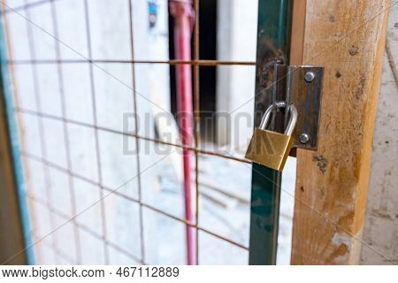 Close Up View On Metal Lattice Door, As A Barrier, Locked Up With Padlock, Entrance For Authorized P