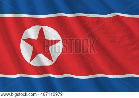 North Korea Flag With Big Folds Waving Close Up Under The Studio Light Indoors. The Official Symbols
