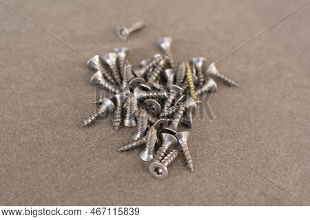 Self Drilling Screws For Roofing With A Drill And With Sealing Washer On Gray Background. Fasteners.