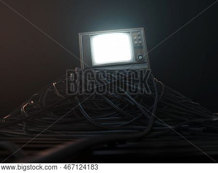 An Illuminated Vintage 80's Television Perched On A Jumbled Pile Of Black Cables On A Dark Omnious B
