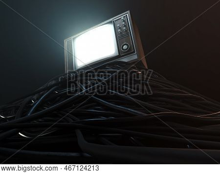 An Illuminated Vintage 80's Television Perched On A Jumbled Pile Of Black Cables On A Dark Omnious B