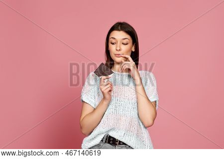 Young Woman In Sweater Holding Chocolate Bar