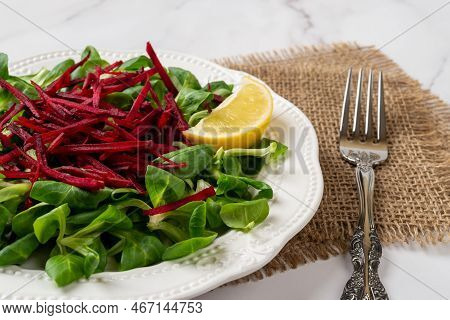 Slimming Salad Of Lambs Lettuce Leaves And Raw Beet. Green Corn Salad And Grated Raw Beet On A White
