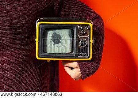Man Sweater Holds Vintage Tv Broken Screen Under His Arm Red Background. Destruction Television Prop