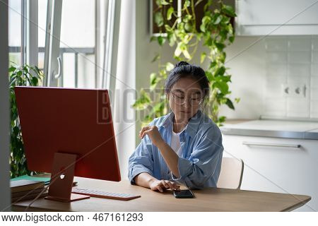 Young Asian Woman Remote Worker Wearing Glasses Touching Smartphone Screen Checking Phone While Work