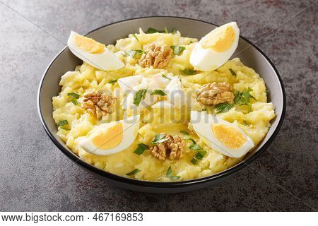 Delicious Mashed Potatoes With Salted Cod And Garlic Served With Walnuts And Boiled Eggs Close-up In