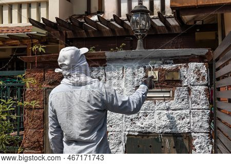Painter Worker Adding Undercoat Foundation Paint Onto Wall With Roller At Residential Building In Re