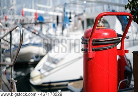 Fire Extinguisher Close-up On The Mooring Of The Yacht Club, Blurred Background. Providing Fire Prot