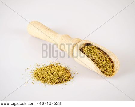 Wooden shovel with hop-suneli and handful of spices next to it