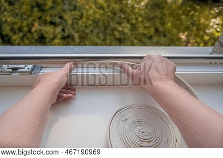 Installation Of Weatherproof Insulation. Worker Sticking Sealing Foam Tape On Indoor Window