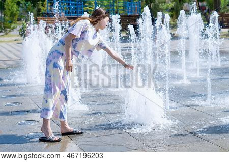 Charming Girl In The Fountain.a Young Pretty Girl Is Bathing In A Dry Fountain In A City Park On A H