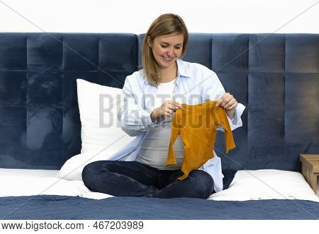 Happy Pregnant Woman Holds Orange Baby Starter Kit, Unisex Baby Long-sleeve Bodysuit Set, Sitting On