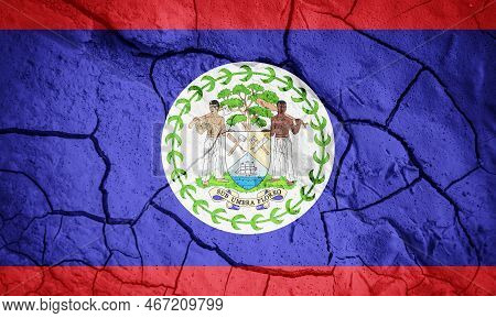 Flag Of Belize. Belize Symbol. Flag On The Background Of Dry Cracked Earth. Belize Flag With Drought